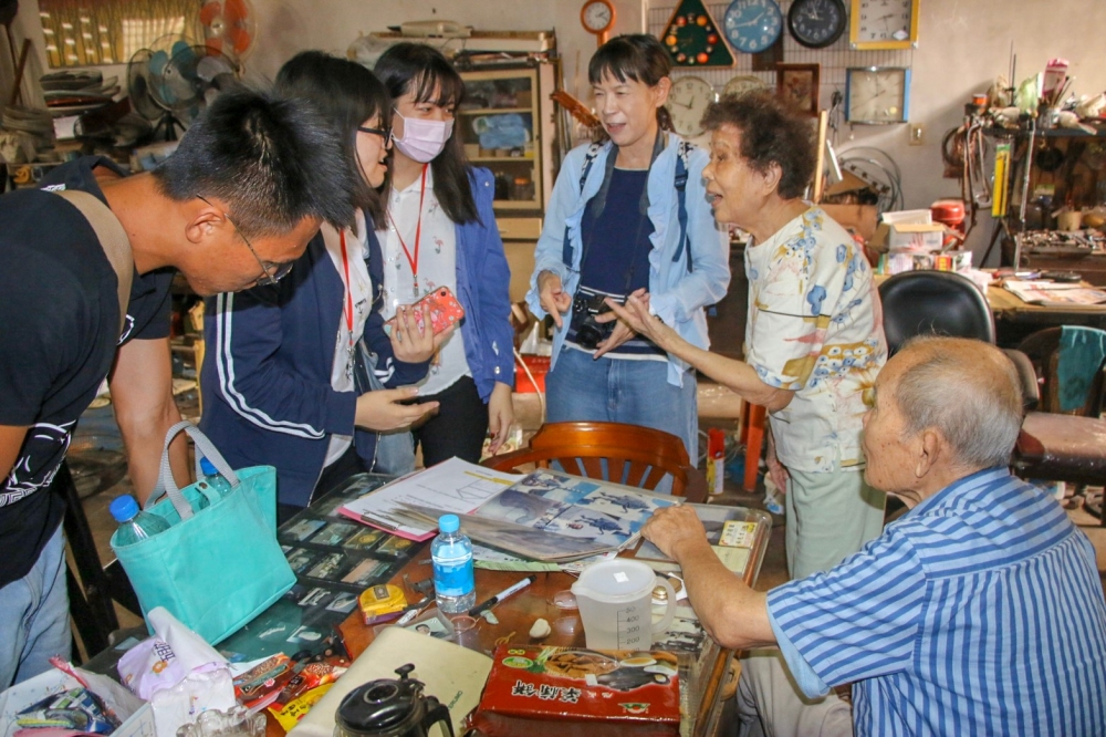 彩繪花燈的學生與認養老屋住民討論花燈彩繪內容的情景