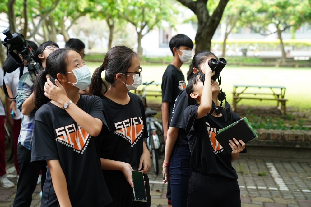 國中學生使用的望遠鏡觀察校園林間鳥類